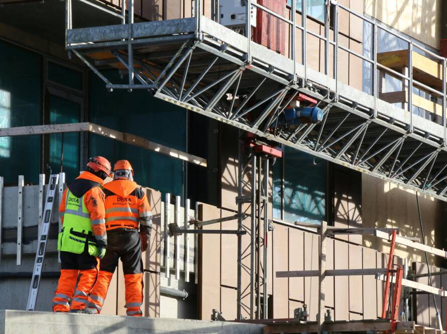 Two Construction Workers Standing on Scaffolding