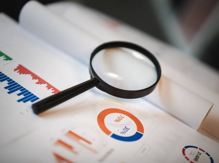 Eine Lupe auf Finanzgrafiken und Diagrammen mit statistischen Daten
